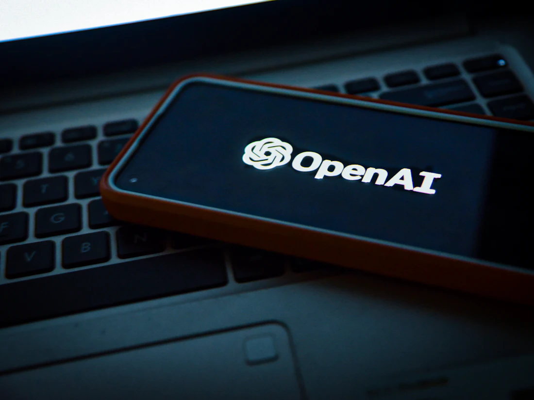 AI assistant open on a phone beside a laptop, representing citation inside generative AI answers