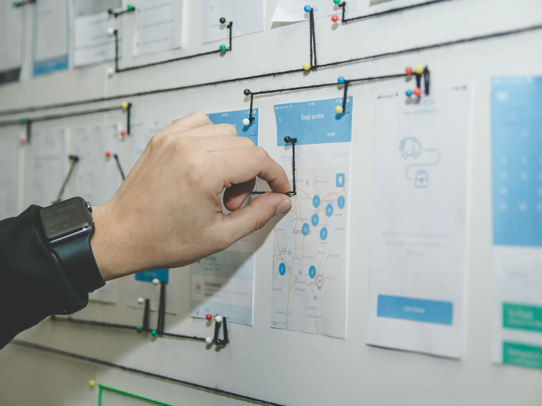 Design team mapping a user journey and interface flow on sticky notes