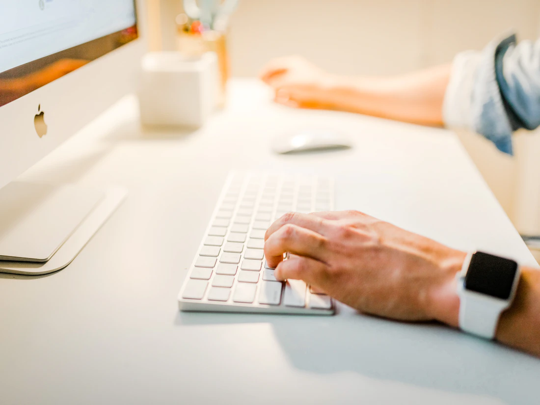 Marketer writing an offer and lead capture page copy at a keyboard